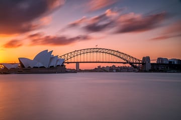 Beautiful shot of the Sydney harbor bridge with a light pink and blue sky in background at sunset